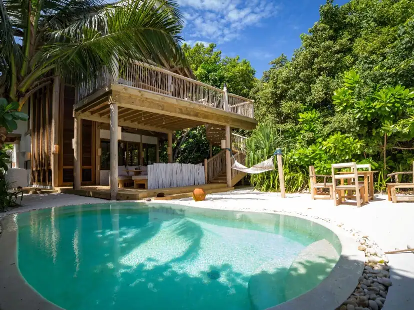 صورة: Soneva Fushi: A tropical duplex villa with a private pool, shaded veranda, hammock, and outdoor seating.