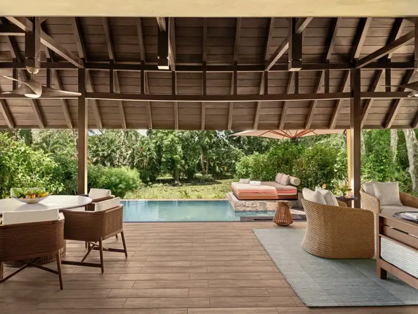 صورة: Four Seasons Resort Mauritius at Anahita: A covered timber patio opens onto a private pool and lush garden, with outdoor dining and cushioned lounge seating.