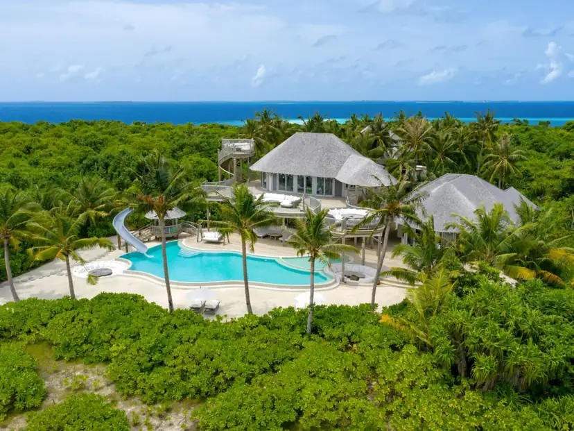 صورة: Soneva Jani: A spacious tropical villa with a private pool, waterslide and outdoor loungers, set amid lush palms with ocean views.