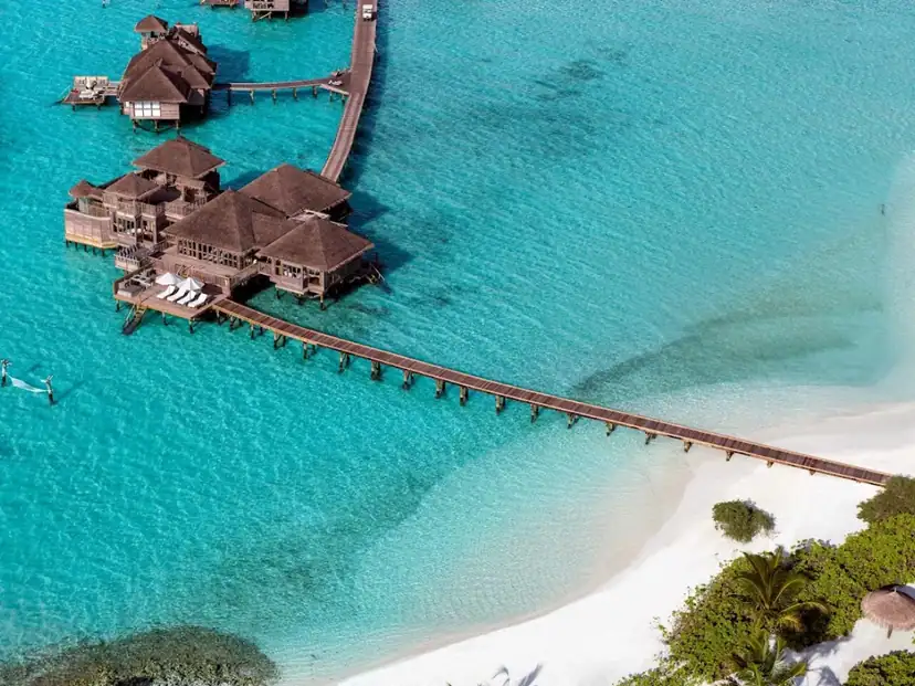 صورة: Gili Lankanfushi: Overwater villas and boardwalks sit above a bright turquoise lagoon beside a white-sand beach.