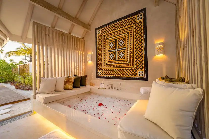 صورة: Rah Gili Maldives: A serene outdoor soaking tub filled with rose petals, surrounded by cushioned loungers and warm ambient lighting under a wooden pergola.