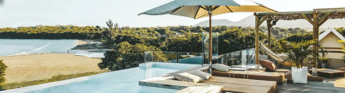 Relax by the pool with sun loungers and open views toward the beach and ocean.